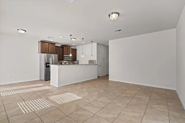 a view of kitchen with granite countertop cabinets and flat screen tv