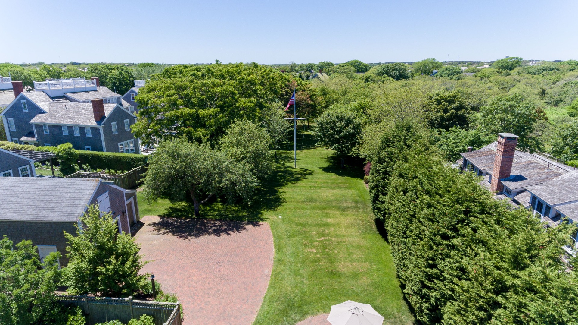24 Cliff Road Nantucket, MA 02554 - Photo 7 of 44 a view of a garden with a building in the background