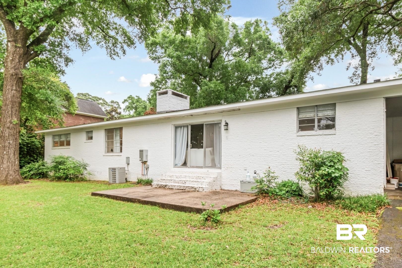 4596 Hawthorne Place Mobile, AL 36608 - Photo 32 of 34 Expansive green lawn with mature trees and a concrete patio