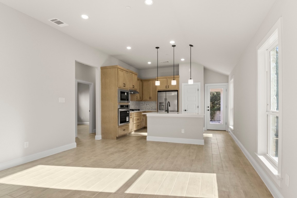 2605 Sam Bass Road, Unit 65 Round Rock, TX 78681 - Photo 15 of 33 a view of a kitchen with kitchen island a refrigerator a sink dishwasher with a dining table and chairs
