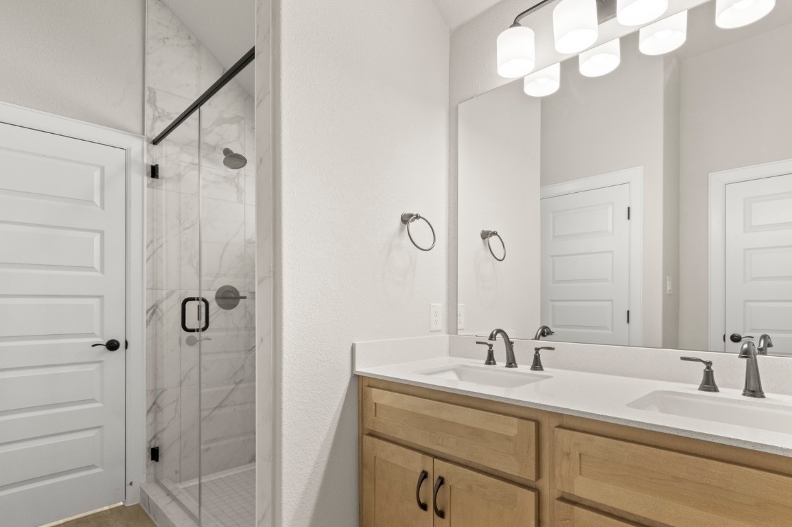 2605 Sam Bass Road, Unit 65 Round Rock, TX 78681 - Photo 26 of 33 a bathroom with a double vanity sink mirror and shower