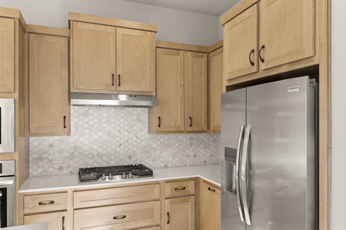 2605 Sam Bass Road, Unit 65 Round Rock, TX 78681 - Photo 31 of 33 a kitchen with a refrigerator and cabinets