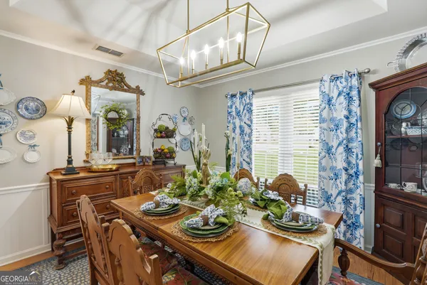 a view of a dining room with furniture a chandelier and wooden floor
