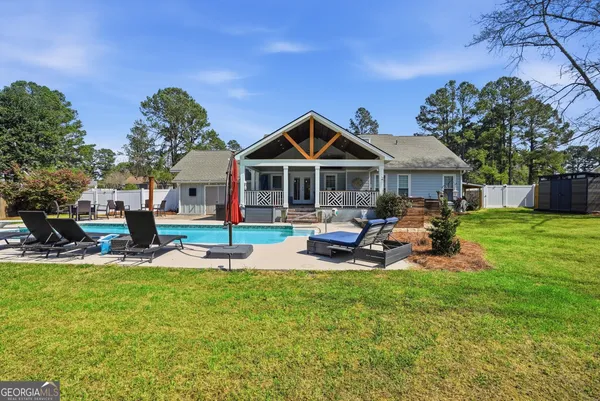a view of a house with swimming pool and sitting area