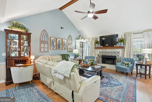 a living room with furniture a fireplace and a flat screen tv