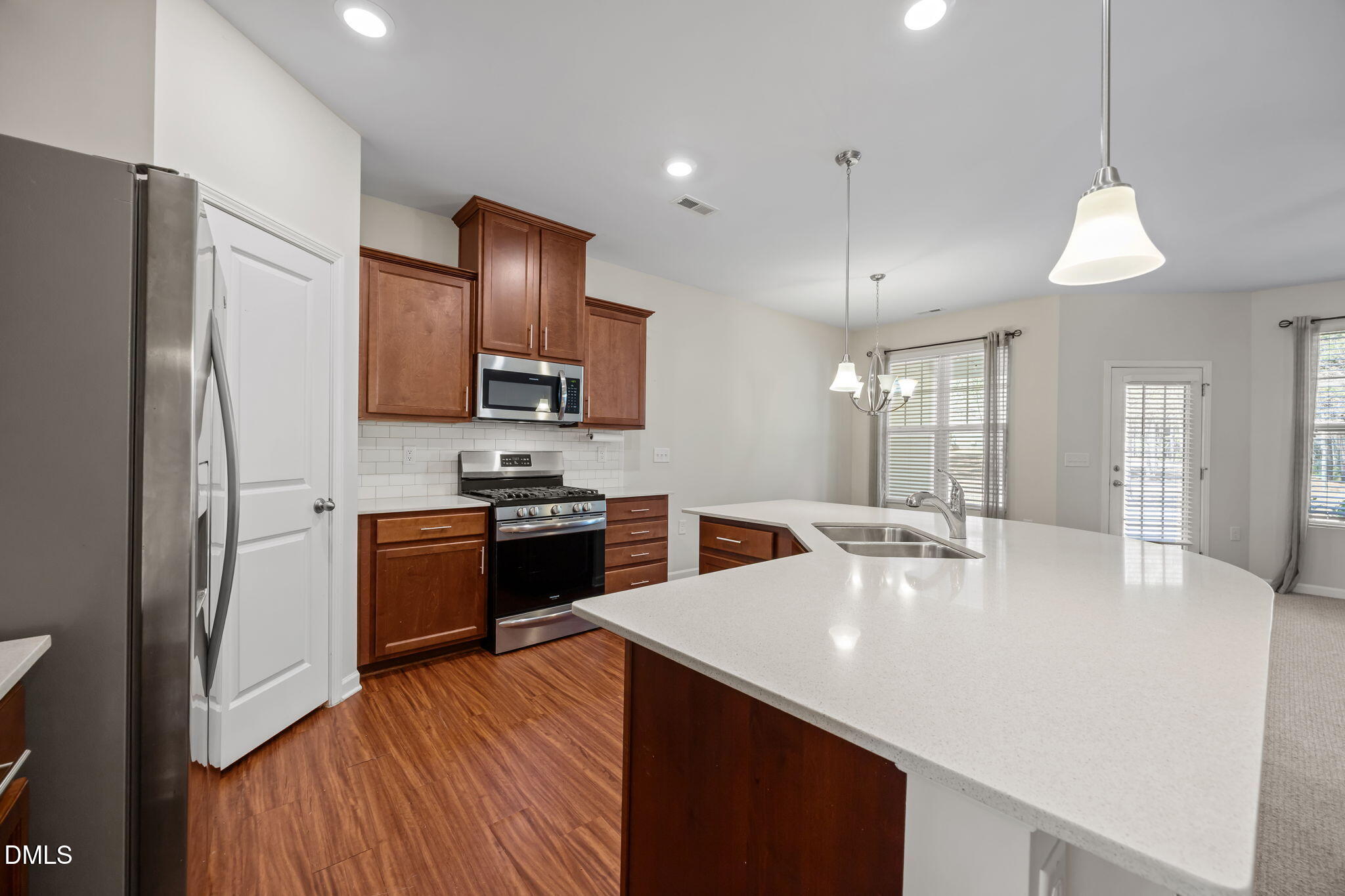 1005 Epiphany Road Morrisville, NC 27560 - Photo 6 of 23 a kitchen with stainless steel appliances granite countertop a sink refrigerator and cabinets