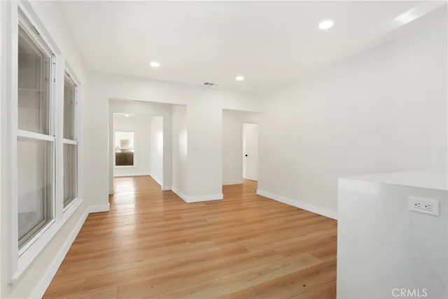 a view of an empty room with wooden floor