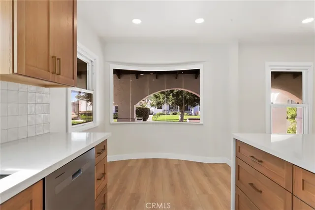 a kitchen with a wooden floor and cabinets