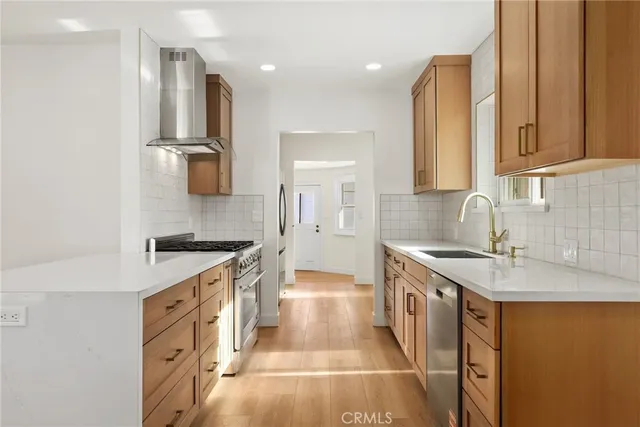 a kitchen with stainless steel appliances granite countertop a sink stove and refrigerator