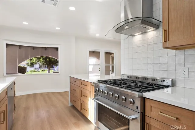 a kitchen with stainless steel appliances granite countertop a stove and a white cabinets
