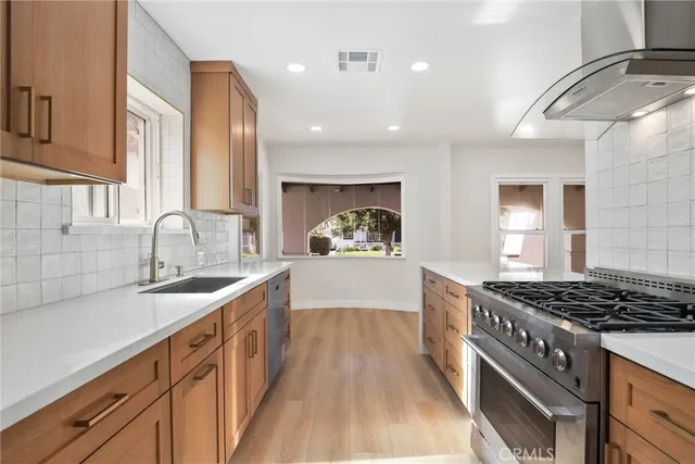 a kitchen with sink a stove and cabinets