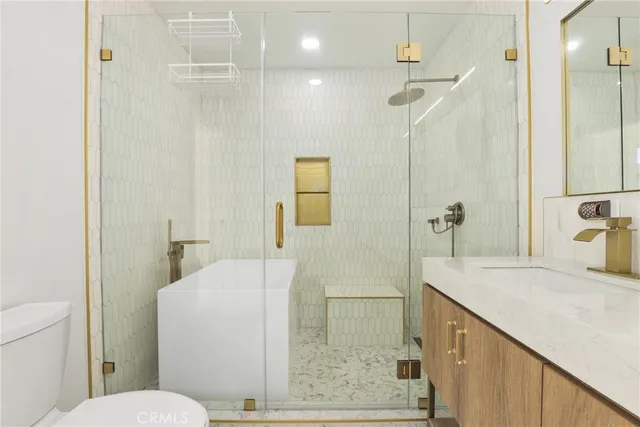 a bathroom with a granite countertop sink a toilet and shower