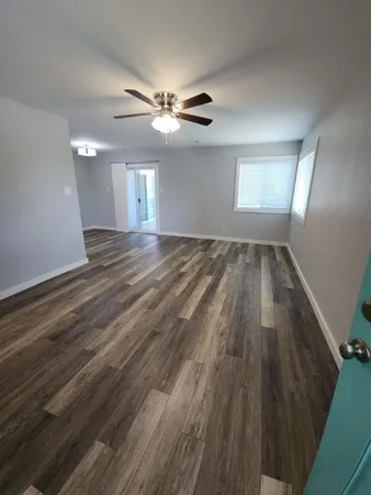 wooden floor in an empty room with a window