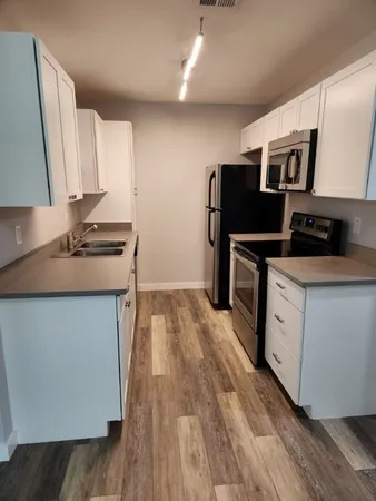 a kitchen with stainless steel appliances granite countertop a stove a sink and a refrigerator