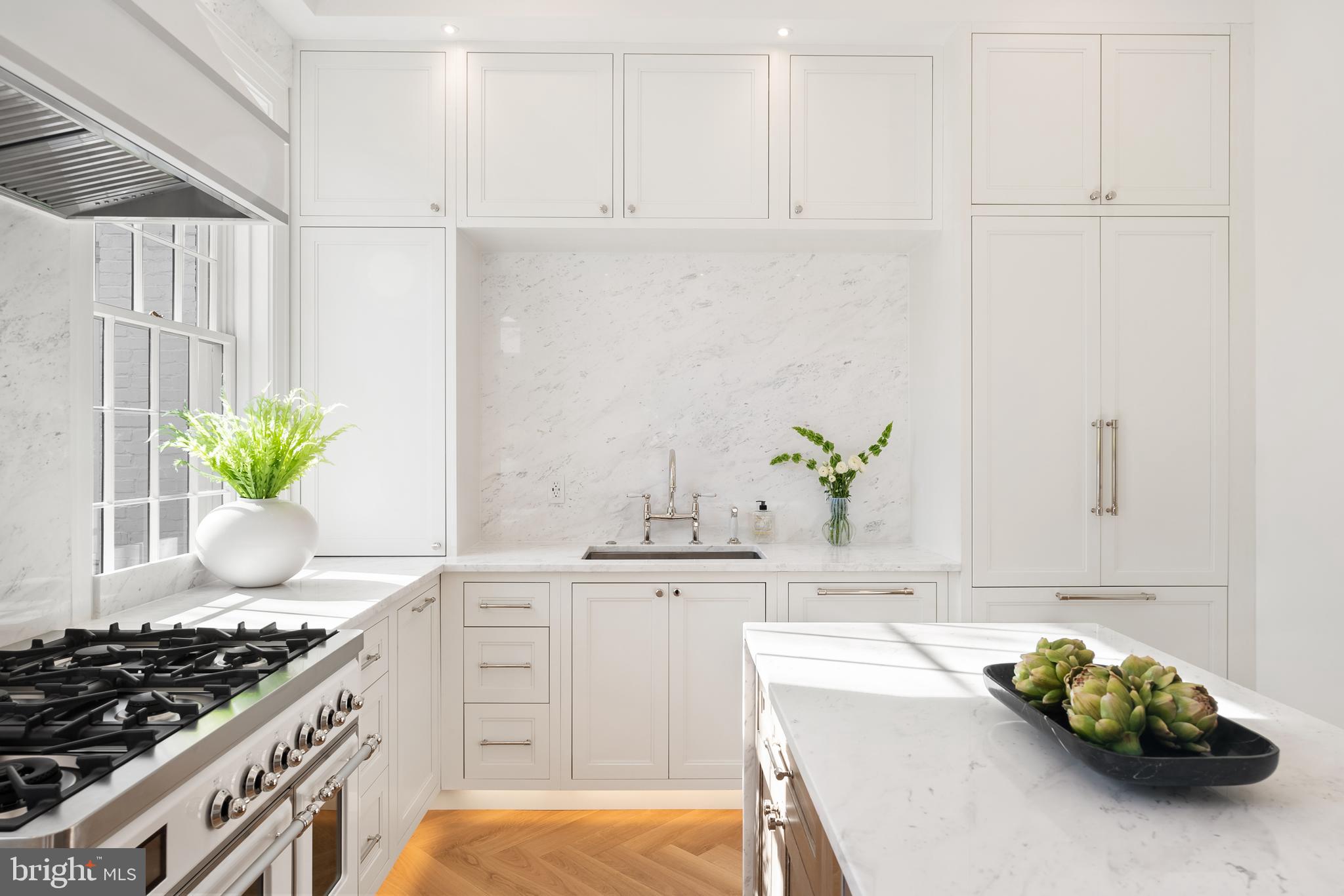 3321 Dent Place Northwest Washington, DC 20007 - Photo 11 of 29 a kitchen with stainless steel appliances a sink a stove and white cabinets