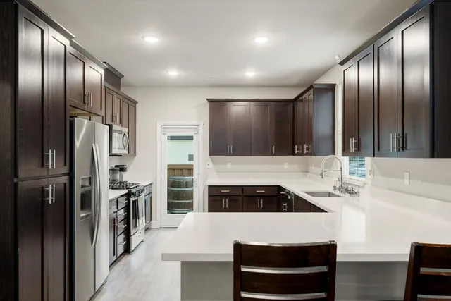 a kitchen with stainless steel appliances a stove a microwave a sink and cabinets