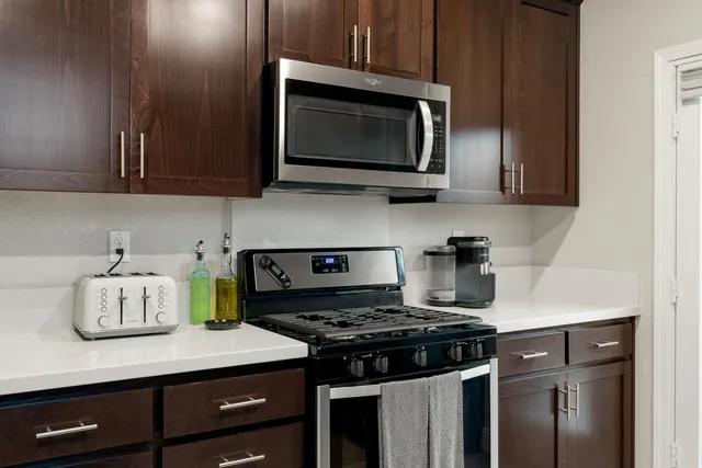 a large kitchen with wooden cabinets and stainless steel appliances
