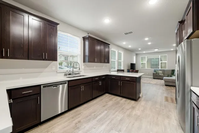 a kitchen with stainless steel appliances granite countertop a refrigerator and a stove top oven