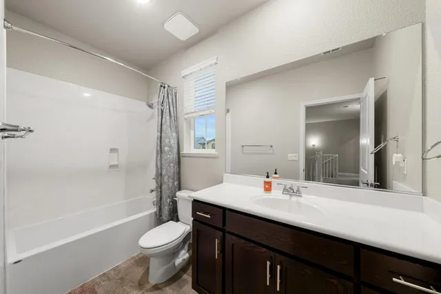 a view of a hallway with bathroom and shower