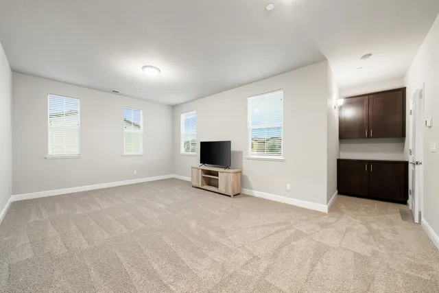 an empty room with windows flat screen tv and windows