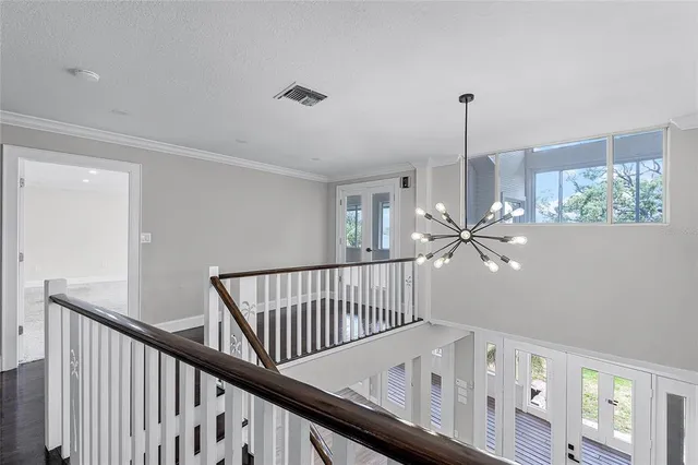 an empty room with windows and ceiling fan