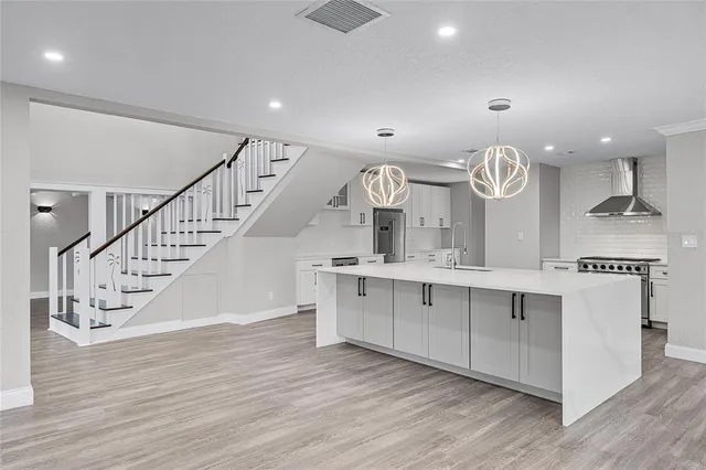 a kitchen with wooden floors and white cabinets