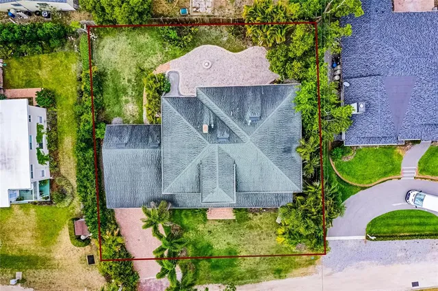 an aerial view of a house with a yard and lake view