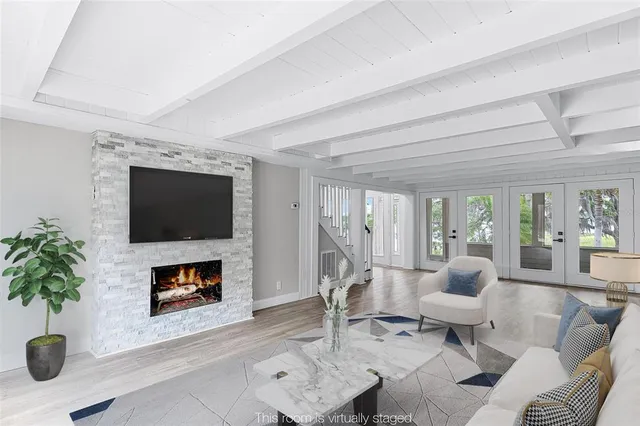 a living room with furniture a flat screen tv and a fireplace