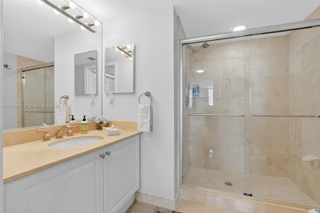 a bathroom with a shower sink and mirror