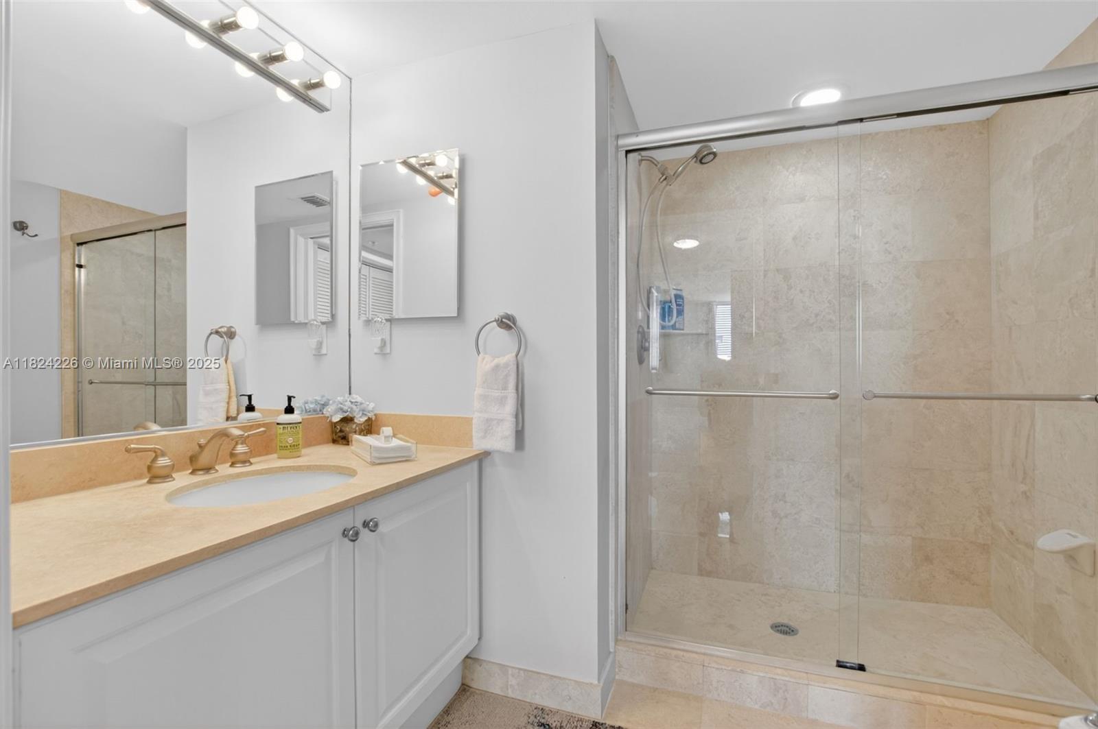 99 Southeast Mizner Boulevard, Unit 821 Boca Raton, FL 33432 - Photo 13 of 23 a bathroom with a shower sink and mirror