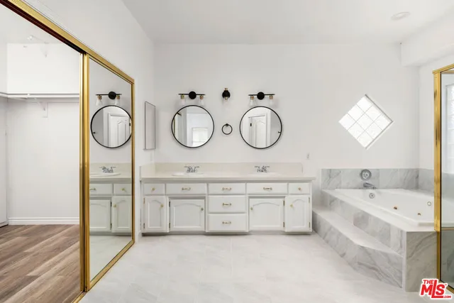 a spacious bathroom with a double vanity sink and a bathtub