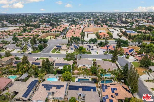 an aerial view of residential houses with outdoor space and swimming pool
