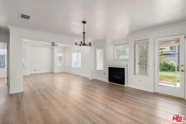 a view of empty room with wooden floor and fireplace
