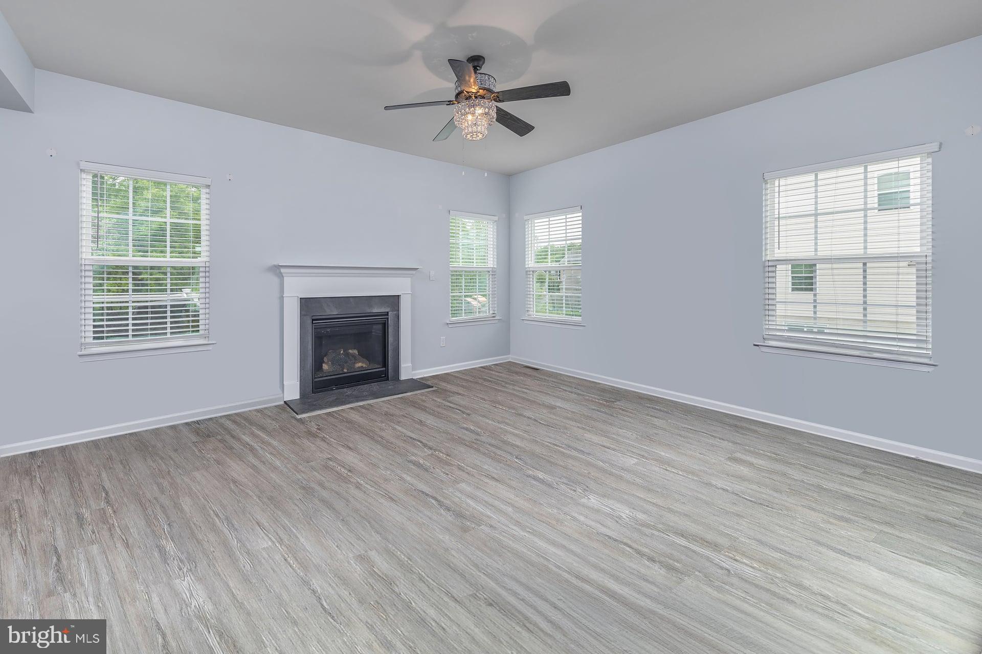 53 Oak Ln. Carneys Point, NJ 08069 - Photo 6 of 28 an empty room with wooden floor fireplace and windows