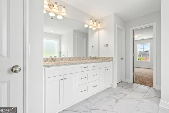 a bathroom with a granite countertop sink a mirror and a shower