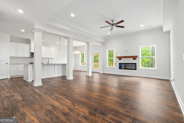 a view of empty room with kitchen and fireplace window