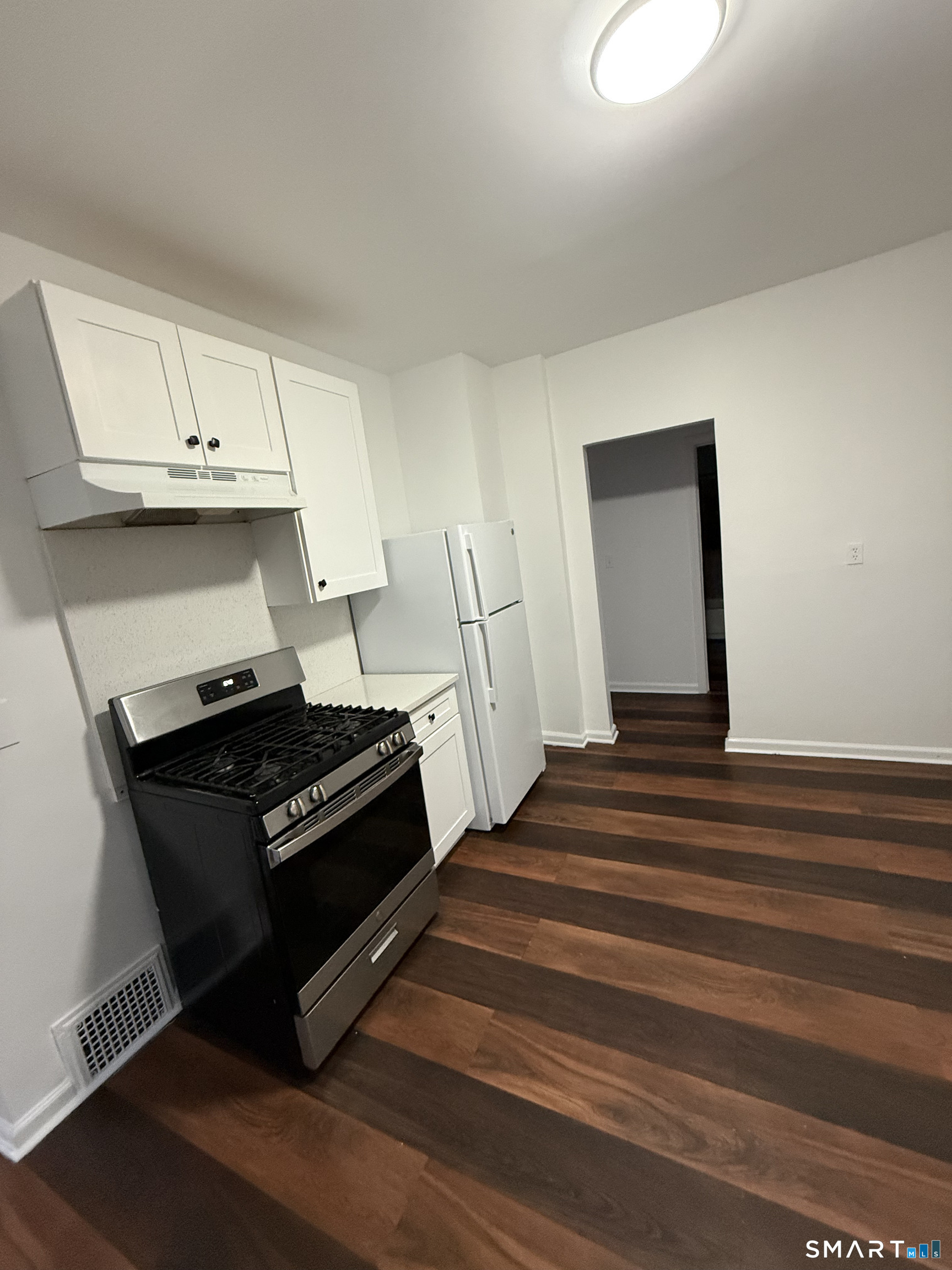 127 Eagle Street Bridgeport, CT 06607 - Photo 8 of 14 The Kitchen is fully renovated with white cabinets, stainless steel appliances and quartz countertops.