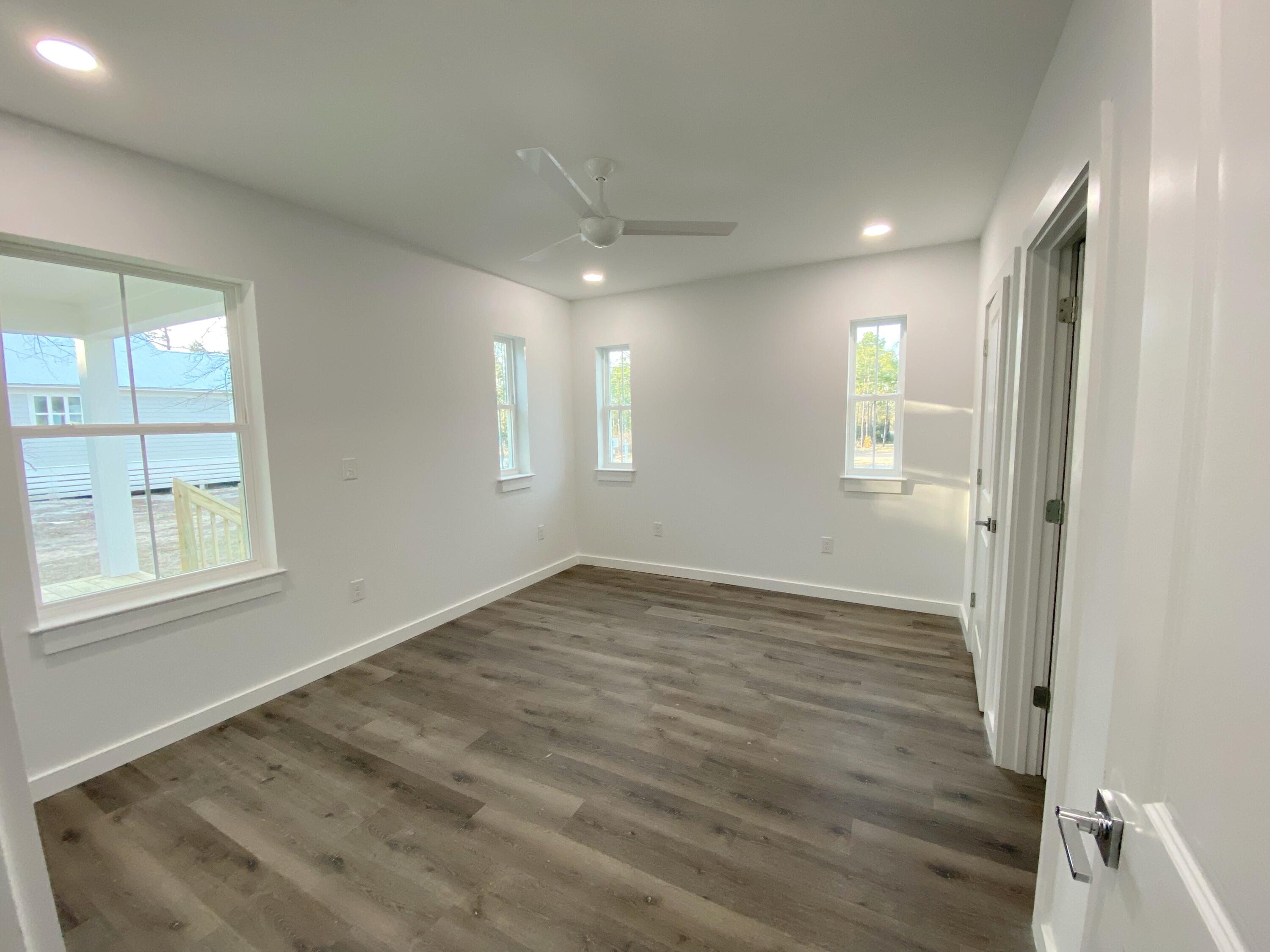211 West Renoir Road DeFuniak Springs, FL 32433 - Photo 13 of 19 an empty room with wooden floor and windows
