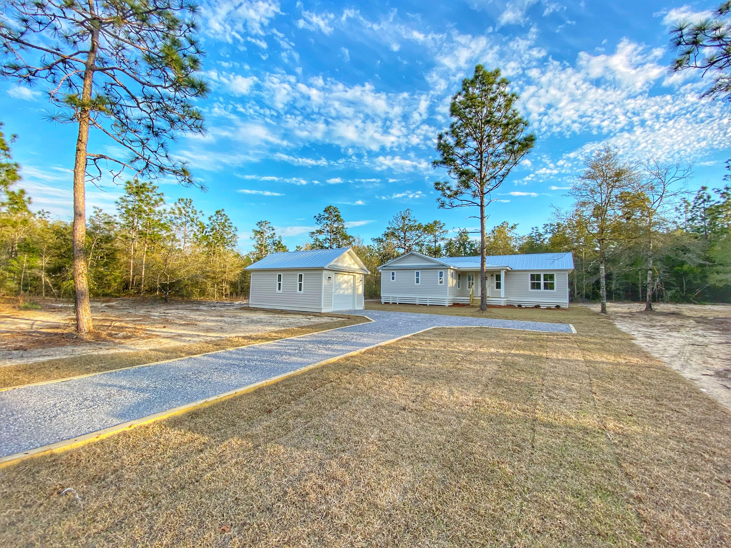 211 West Renoir Road DeFuniak Springs, FL 32433 - Photo 3 of 19 a view of a house with a yard and large trees