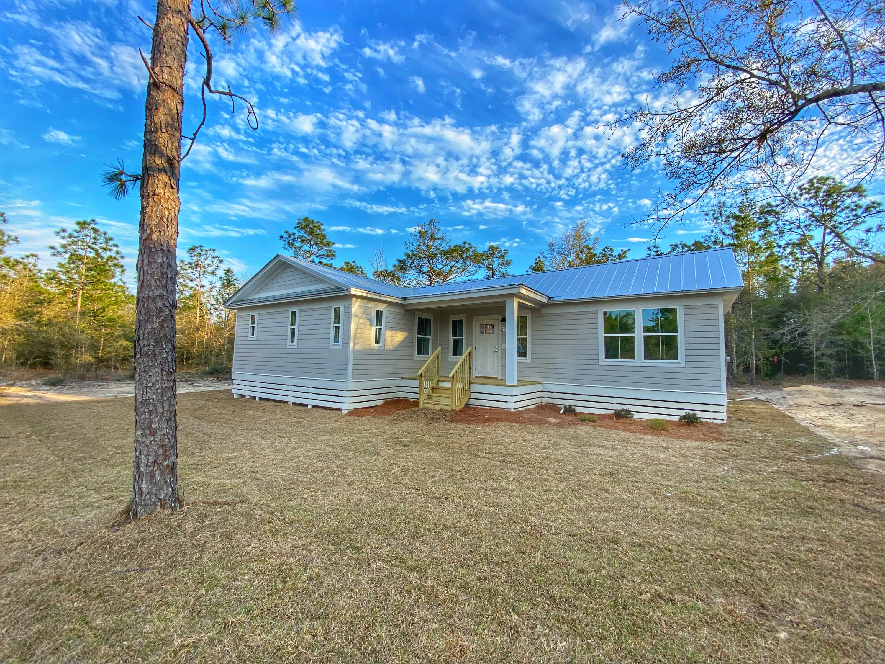 211 West Renoir Road DeFuniak Springs, FL 32433 - Photo 5 of 19 a front view of house with yard and trees in the background