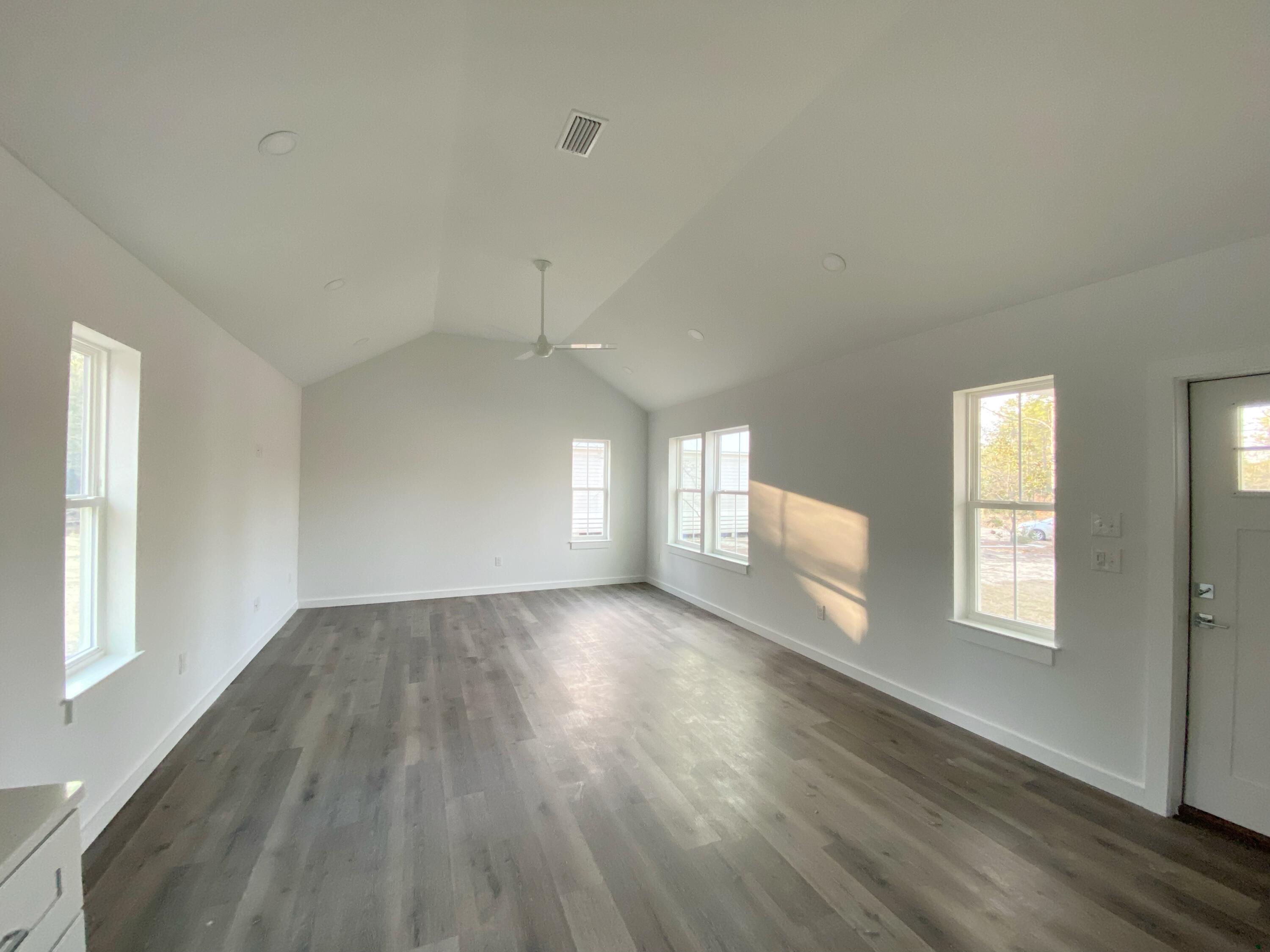211 West Renoir Road DeFuniak Springs, FL 32433 - Photo 8 of 19 an empty room with wooden floor and windows