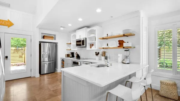 a kitchen that has a sink a refrigerator and a stove top oven