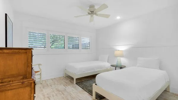 a bedroom with two beds and a chandelier