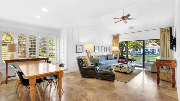 a living room with furniture and floor to ceiling windows