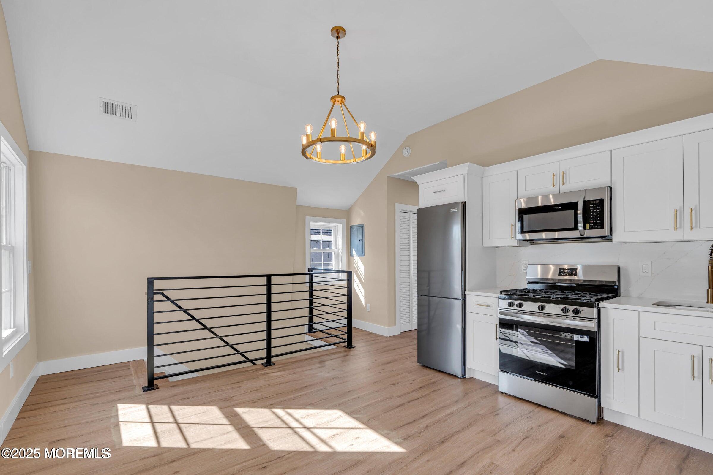 39 Sea Drift Avenue Highlands, NJ 07732 - Photo 5 of 12 a hallway with stainless steel appliances a stove a microwave and a refrigerator