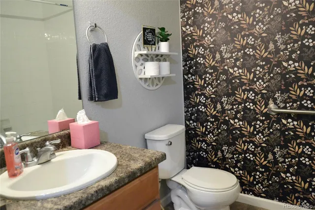 a bathroom with a granite countertop toilet sink and mirror