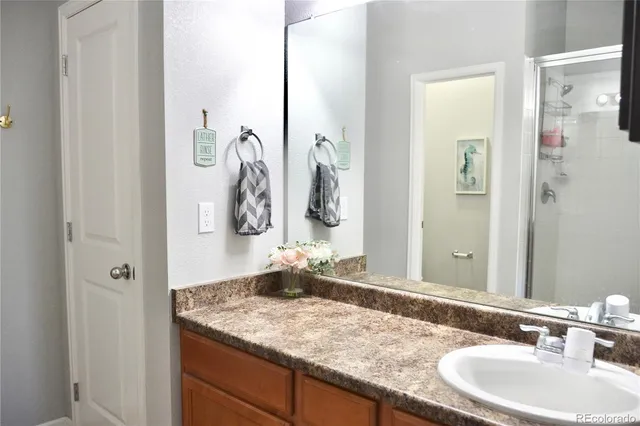 a bathroom with a granite countertop sink and a mirror