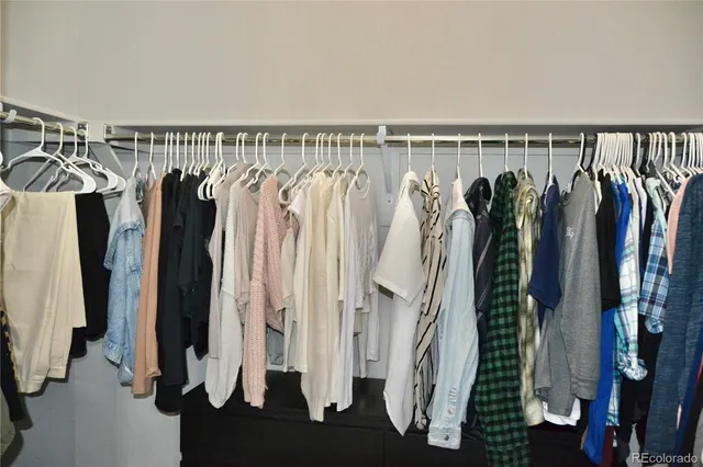 a view of walk in closet with clothes and shoes