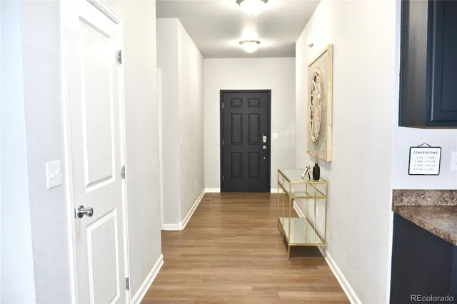 a view of a hallway with wooden floor and entryway