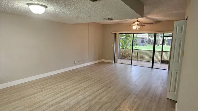 an empty room with wooden floor and balcony